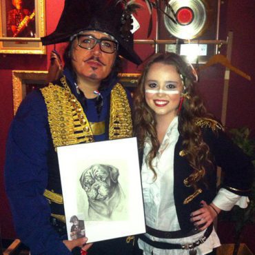 Adam Ant, singer of Adam and The Ants, with Artist Chelsea Smith holding her original pencil pet portrait she did of his pet dog.